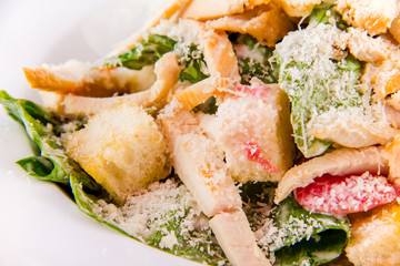 Plate with fresh caesar salad. Closeup macro on white background