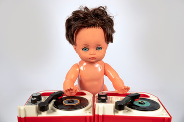 Plastic doll djing on toy record player