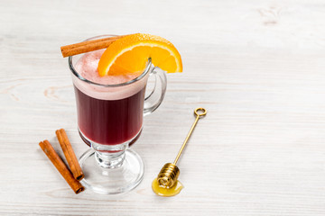 Mulled wine with a slice of orange, cinnamon and honey
