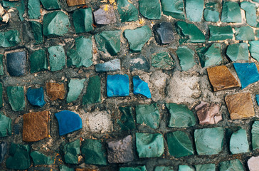 Detail of a beautiful multi-colored old crumbling abstract ceramic mosaic decoration on a building. Venetian mosaic as a decorative background. Selective focus