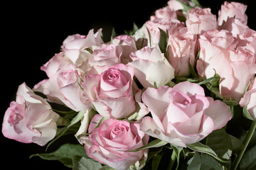 Close-up of a flower bouquet with pink roses isolated on a black background