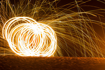 Juggler swinging fire on the beach