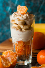 Yogurt with banana, mandarin and oatmeal. Tasty and healthy breakfast