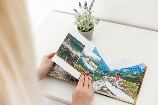 Young blond woman holding a photo album. photobook