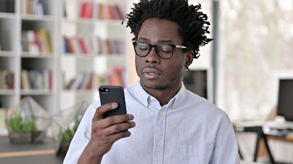 Portrait of African Man using Smartphone, Browsing Internet