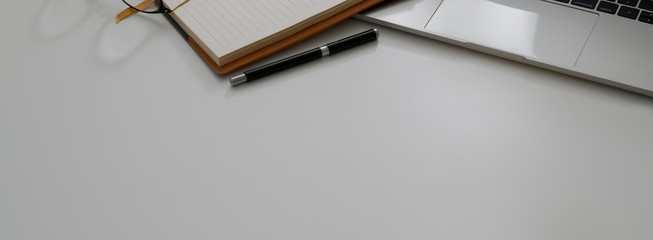 Cropped shot of modern office desk with laptop, office supplies and copy space