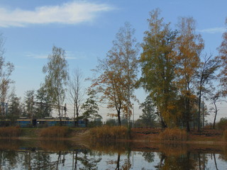 Jesienny krajobraz nad sadzawką z lokomotywą w tle