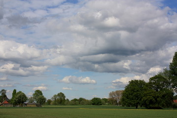 Wolkenbildung mit blauen Himmel, Feld und Bäumen