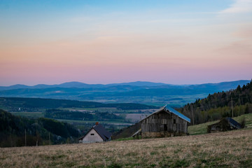 Obraz premium Mountain landscape with wooden hut during sunset time. Shot in Poland, Sudetes Mountains. 