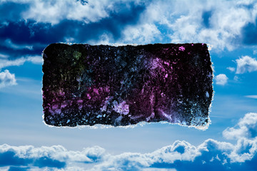 A hole in the day sky with torn edges, as if on paper, with a view into space with stars, nebulae...