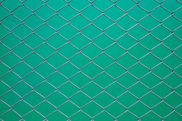 Stainless still Wire mesh rhombus form on green background. Still wire mesh fence.