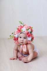 baby girl in a hat of roses