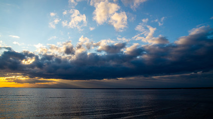 Fototapeta na wymiar Sunset on the seashore, beach, dramatic clouds.