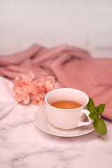 Pausa relax con libro, tè caldo e peonie rosa