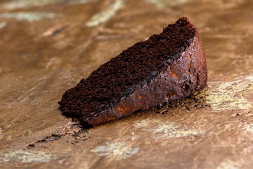 Close-up of slice of chocolate cake, on antique marble surface