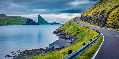 Dramatic summer scene of Faroe Islands and Tindholmur cliffs on background. Panoramic morning view of Vagar island, Denmark, Europe. Traveling concept background.