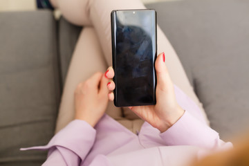Young woman using apps on a mobile touchscreen smartphone. Concept for using technology, shopping online, mobile apps, texting, addiction, swipe up, swipe down.