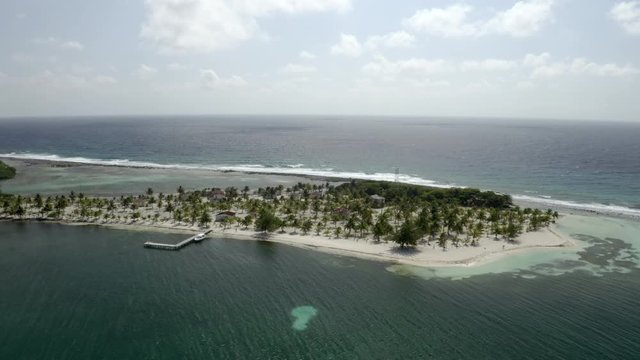 Aerial panning footage of resort and trees on island amidst sea - Coco Plum Cay, Belize