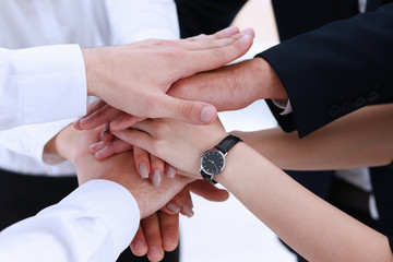 Group of people in suits crossed hands in pile for win closeup. White collar leadership, high five, cooperation initiative achievement, corporate life style, friendship deal, heap, stack concept