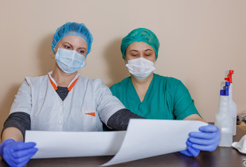 A female doctor in a sterile mask and uniform on a break after prevention during the covid-19...