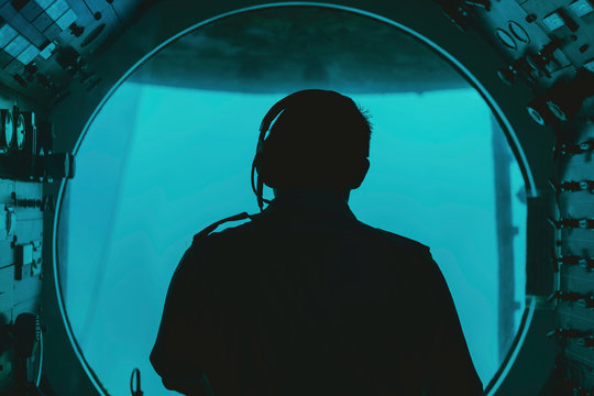 silhouette of a pilot in submarine cockpit under water