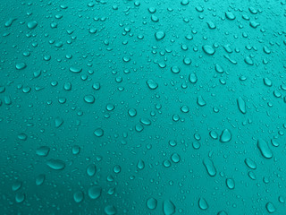 Fototapeta na wymiar Drops of water on a turquoise metal surface, beautiful background after rain