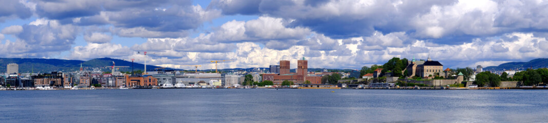 Obraz premium Oslo, Norway - Panoramic view of Oslo waterfront with Akershus Fortress, City Hall and Aker Brygge borough at Pipervika harbor