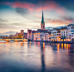 Dramatic evening view of Fraumunster Church. Colorful autumn cityscape of Zurich, Switzerland, Europe. Sunset on Limmat River. Traveling concept background..