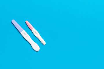 Colored Pregnancy test on colored background, top view with copy space