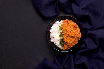 Dhal Indian lentil soup with rice on a black background. Copy space. Traditional indian food concept