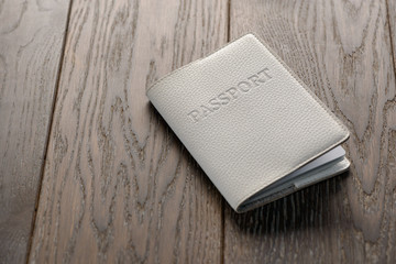Passport in white cover on wooden table
