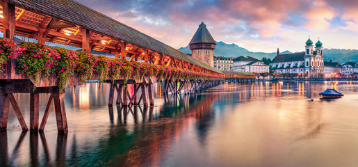 Famous old wooden Chapel Bridge (Kapellbrucke), landmark 1300s wooden bridge with grand stone water tower & a roof decorated with 17th-century art. Lucerne cityscape, Switzerland, Europe.