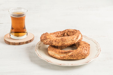 Simit that is Turkish bagel and tea on a wooden table