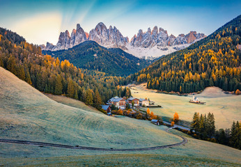 Stunning view of Santa Magdalena village with Chiesetta di San Giovanni in Ranui church in front of the Geisler. Gorgeous autumn sunrise on Dolomite Alps, Italy, Europe. Traveling concept background.