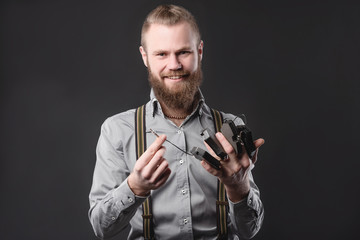 Handsome young man presents car parts on a gray background. The concept of sales and testing of goods