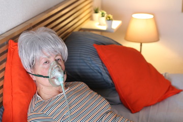 Senior woman using oxygen mask 