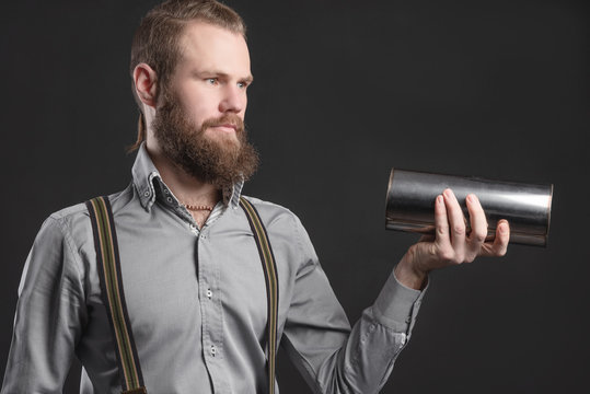Handsome young man presents car parts on a gray background. The concept of sales and testing of goods
