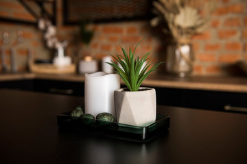 a vase with a flower on the black table in the kitchen with a modern  loft interior