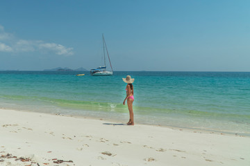 Fototapeta na wymiar Woman on paradise blue beach. Tourist on Whitsundays beach, white sand, in pink bikini & hat, with aqua turquoise ocean. Travel, holiday, vacation, paradise, exotic. Whitsundays Islands, Australia.