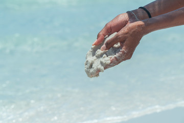 Fototapeta na wymiar Hand holding white beach sand. Famous white silica sand. Whitehaven beach, Whitsundays. Turquoise ocean, white sand. Travel, holiday, vacation, paradise. Shot in Hill Inlet, Queenstown, Australia.
