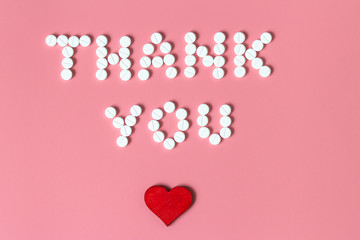 International's nurses day, week concept, Text Thank you by tablets and red heart on pink background.