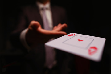 Close-up of male hand throwing trump card. Professional player or magician in presentable suit....