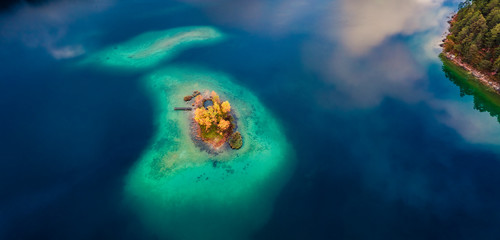 Straight-down view from flying drone. Small island on Eibsee lake. Beautifel autumn scene of Bavarian Alps, Germany, Europe. Beauty of nature concept background.