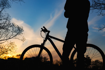 Obraz premium Silhouette of a cyclist at sunset against the sky