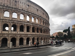 Fototapeta na wymiar Tourists walking around Coliseum, Rome, Italy, in a stormy day