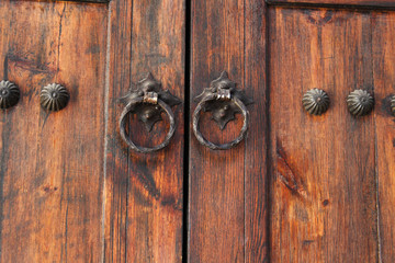 Iron knocker on an old wooden door