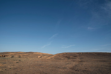 A hill in the steppe under a blue sky