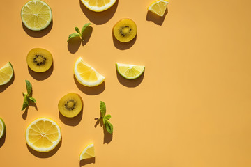 Sliced fruits kiwi, citrus and mint leaves on bright background