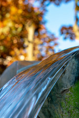 Nahaufnahme von fließend Wasser, umgeben von Stein und Blattwerk im Hintergrund