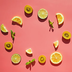 Sliced fruits kiwi, citrus and mint leaves on bright background